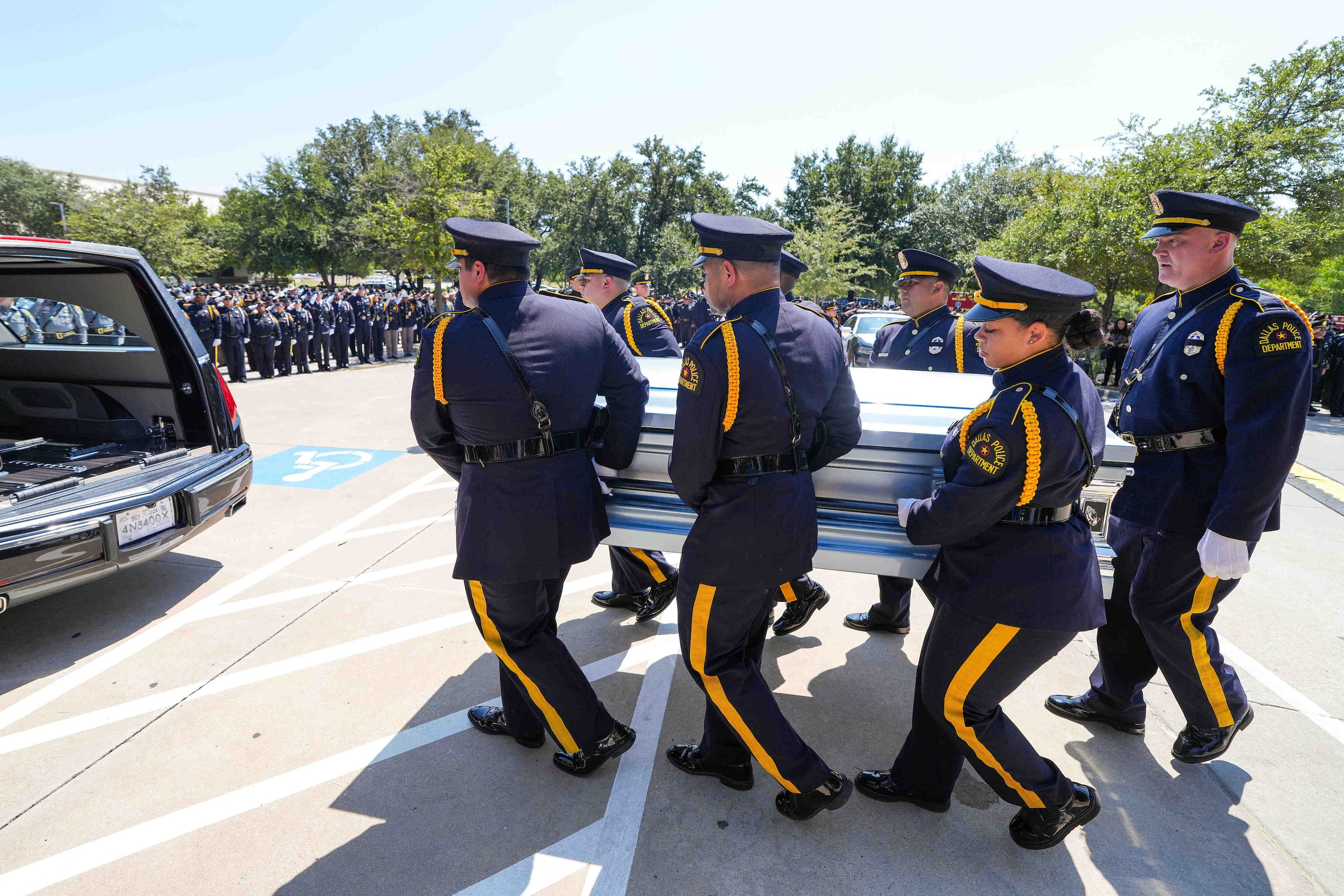 Members of the Dallas Police Honor Guard carry the casket to a hearse following funeral...