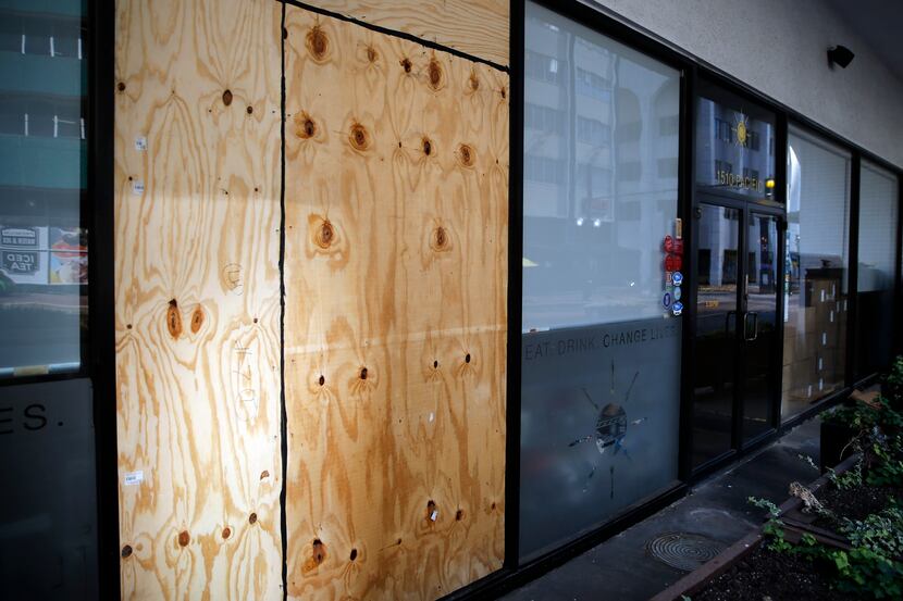 Plywood has been installed to cover the spot where one of Café Momentum's large street-side...