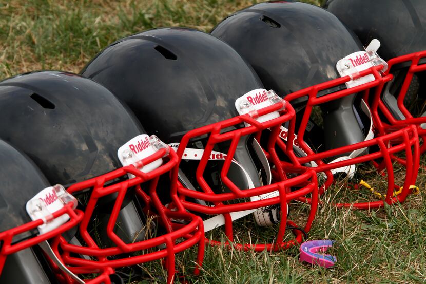 A row of new football helmets await youth football players from the Akron Parents Pee Wee...