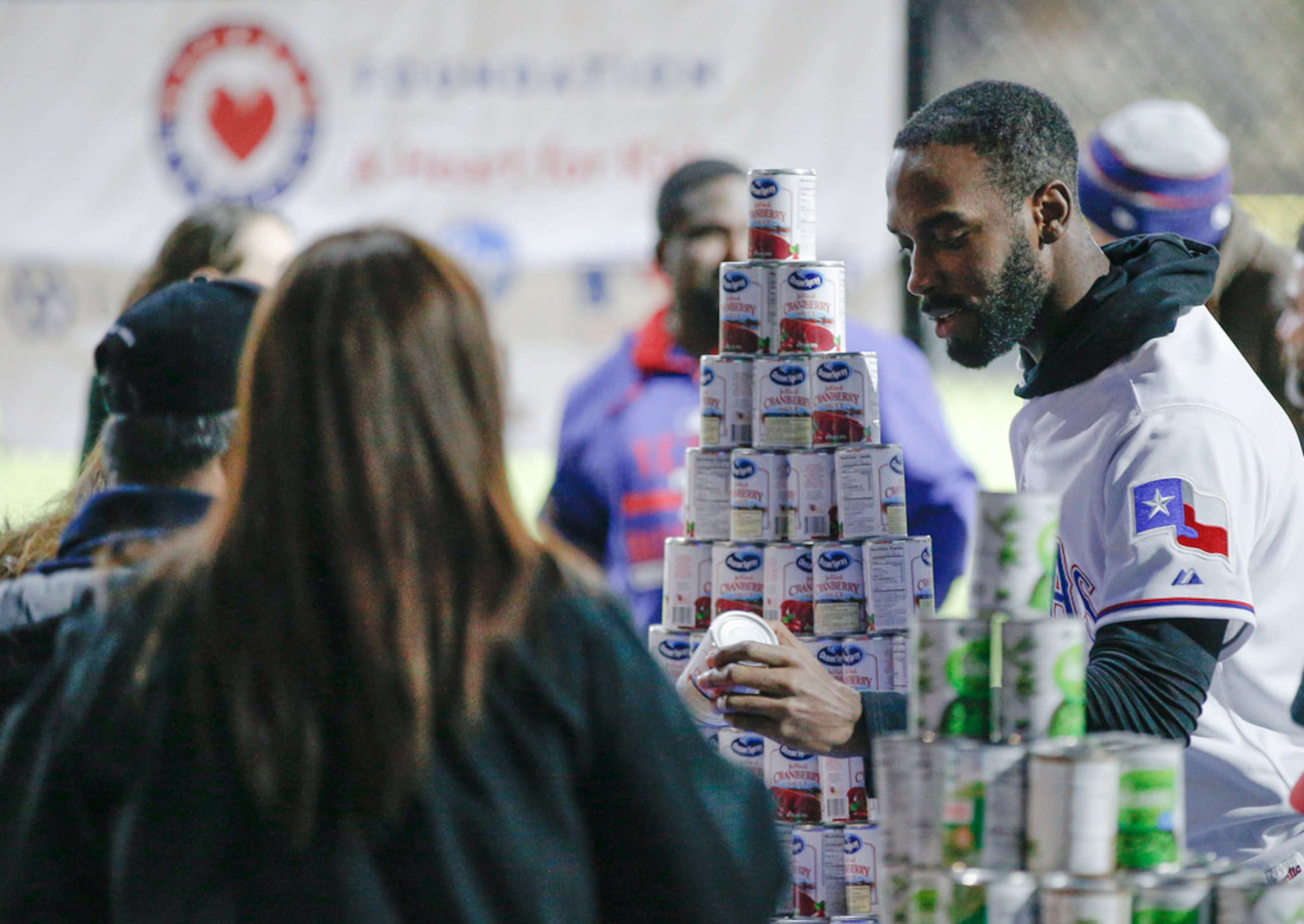 Texas RangersÃ Taylor Hearn hands out cans of cranberry sauce and other Thanksgiving...