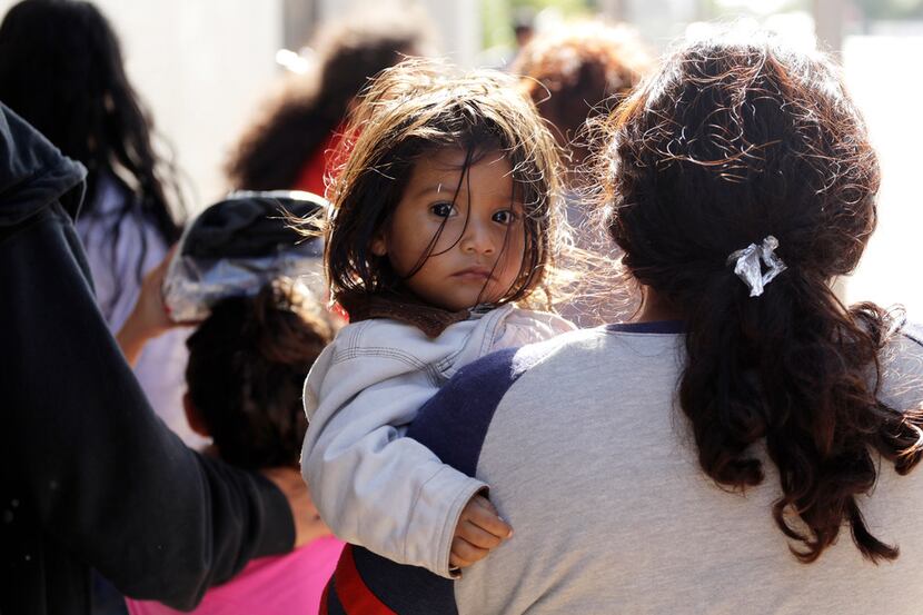 Immigrant families walk to a respite center after they were processed and released by U.S....