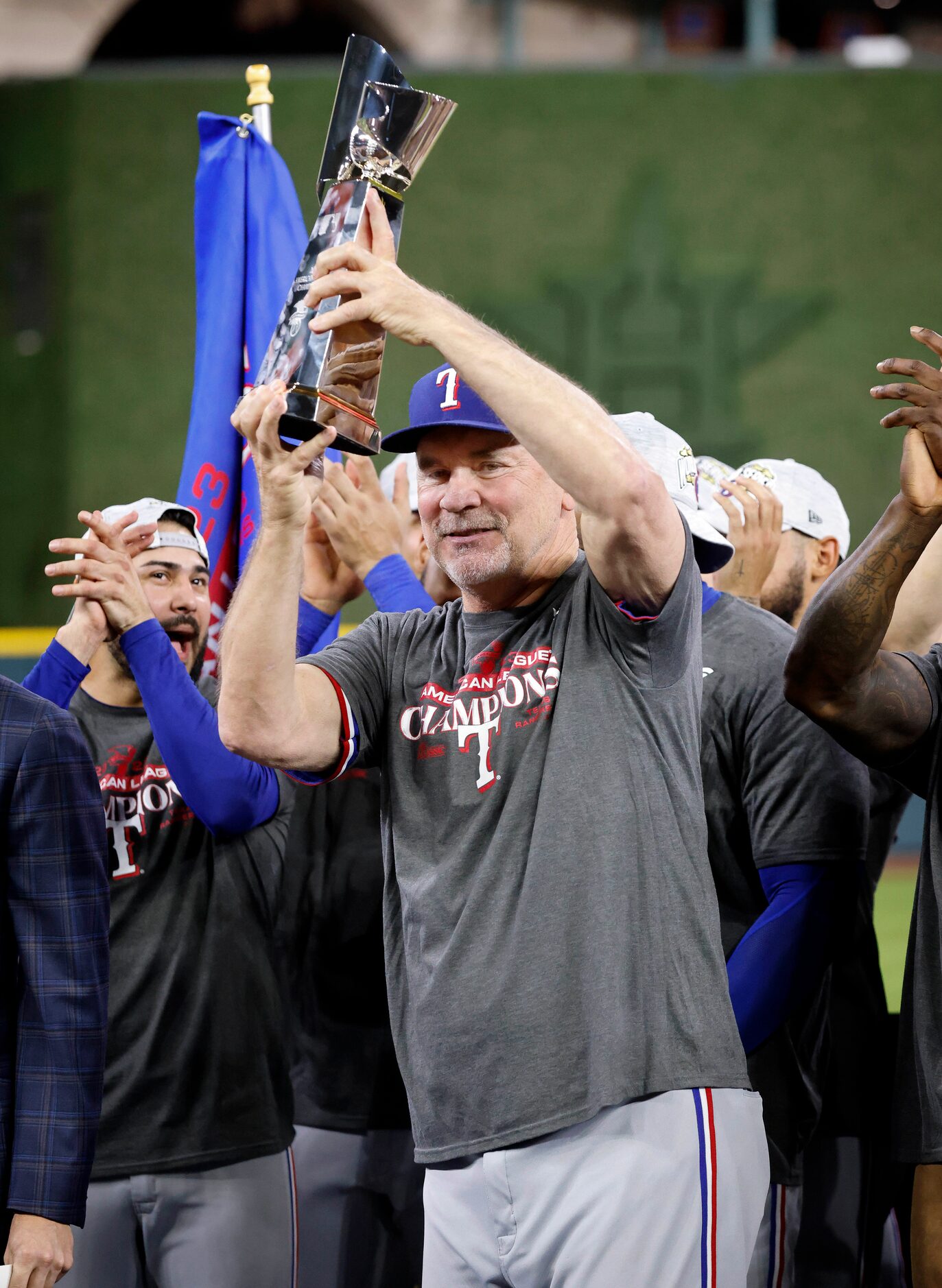 Texas Rangers manager Bruce Bochy hoists the winning ALCS trophy after defeating the Houston...