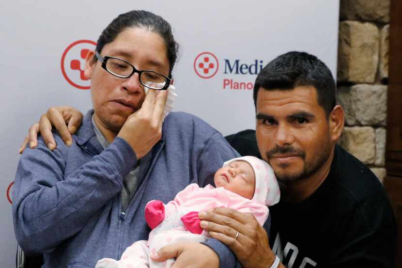 Nora Uribe holds her newborn baby daughter, Ximena, with her husband Antonio Negrete at her...