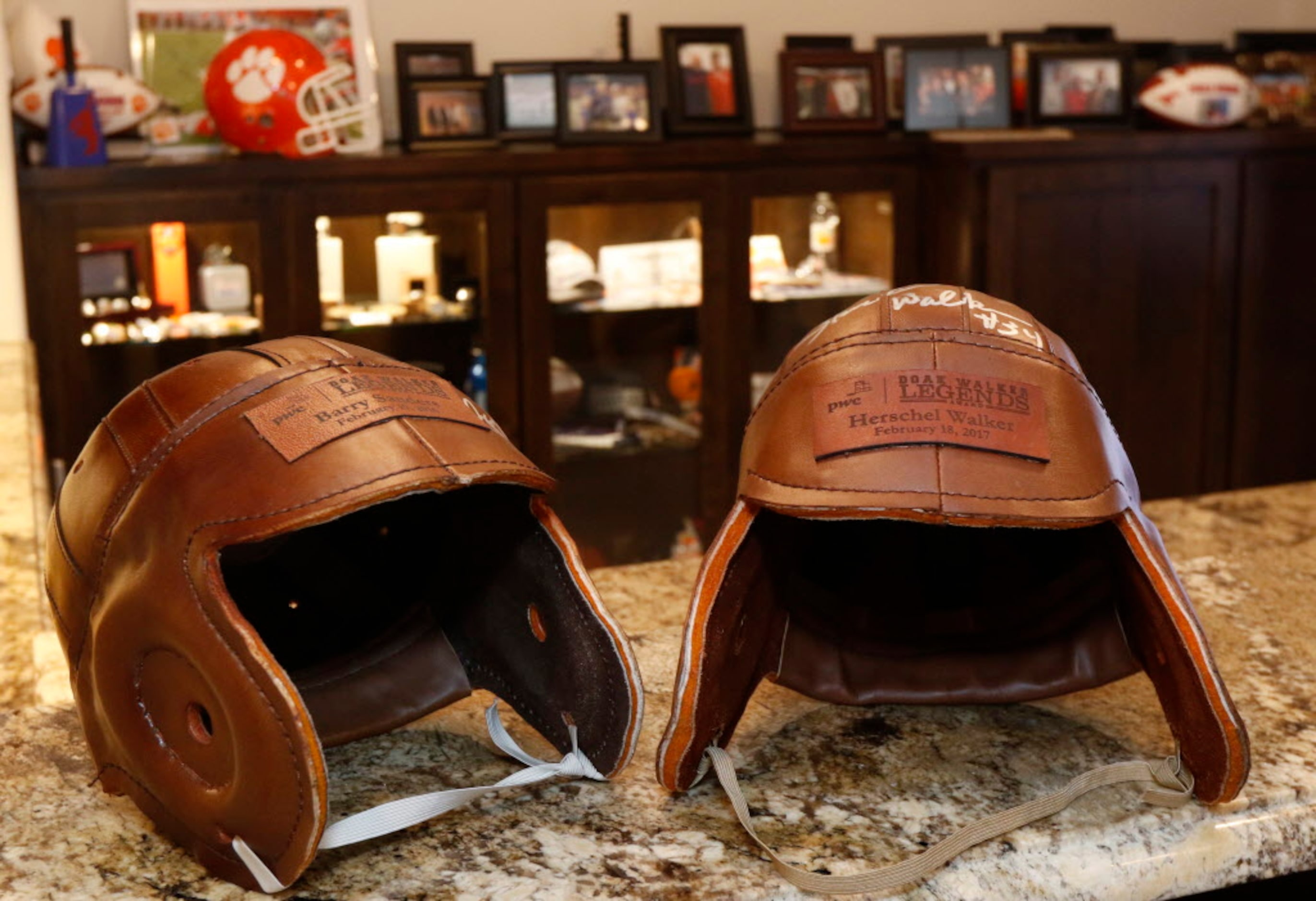 Leather football helmets signed by Barry Sanders, left, and Herschel Walker are part of SMU...