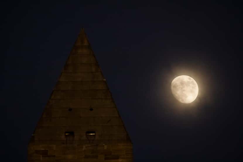 The Washington Monument is shown as the moon rises in Washington, D.C., on Saturday, Dec....