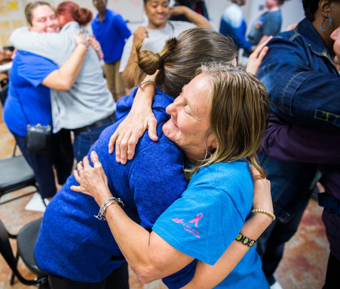 Kristie Loveland, left, hugs Joyce Sharp, right, during a group session at the Austin Street...