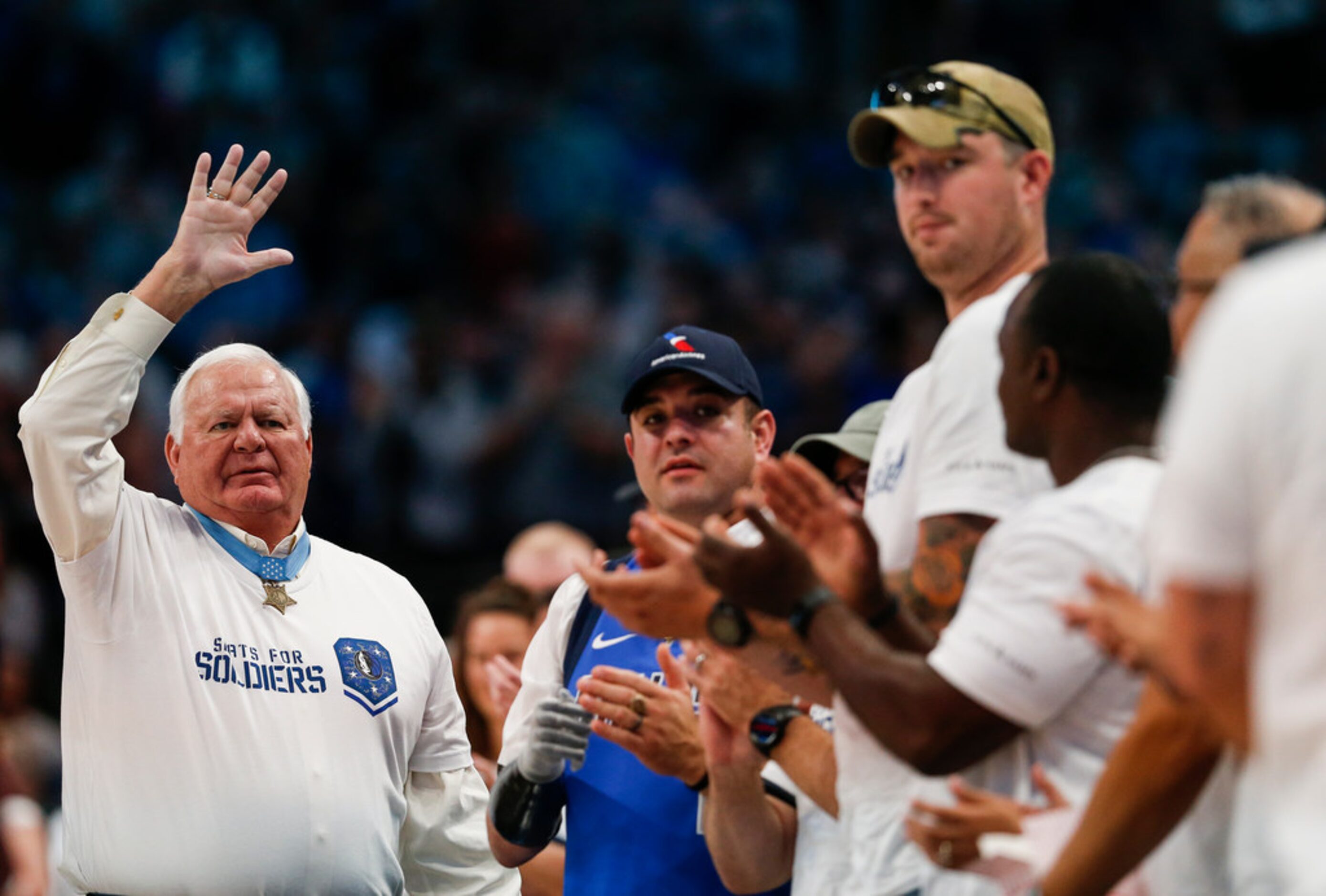 Veterans and members of the armed forces fill court-side seats for an NBA game between the...