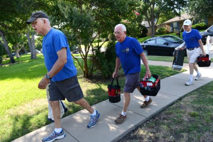 Volunteers for Plain-O Helpers Jim Sackett, left, and Ed Sweeney walk to the front door of...