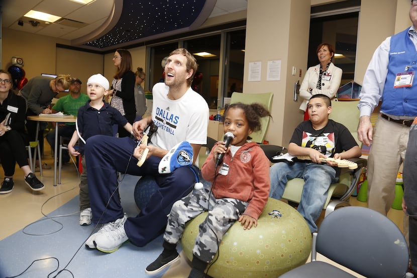Dirk Nowitzki plays Guitar Hero with patients at Children's Medical Center on a recent visit.