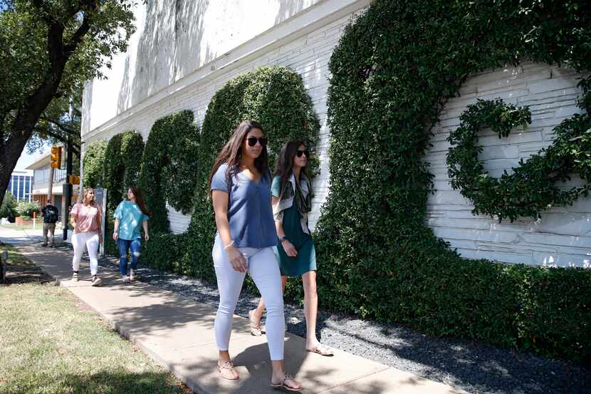 Sara Salvatierra (left) and Simone Henderson walk around the Simpli.fi building in Fort Worth.