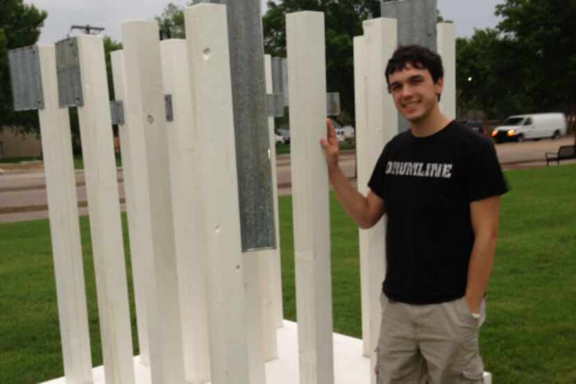Connor Walden stands with his art sculpture 'Life," which is on display at the corner of...