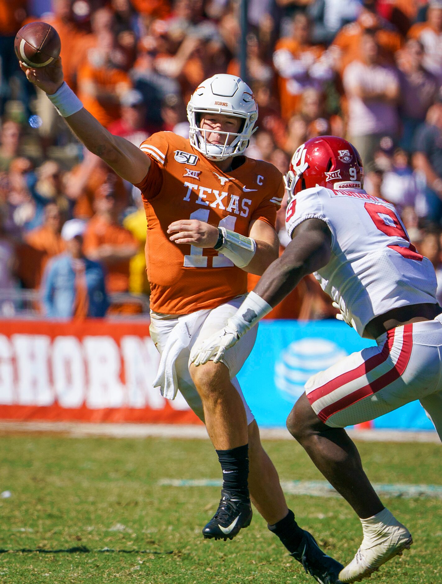 Texas quarterback Sam Ehlinger (11) throws a pas under pressure from Oklahoma linebacker...