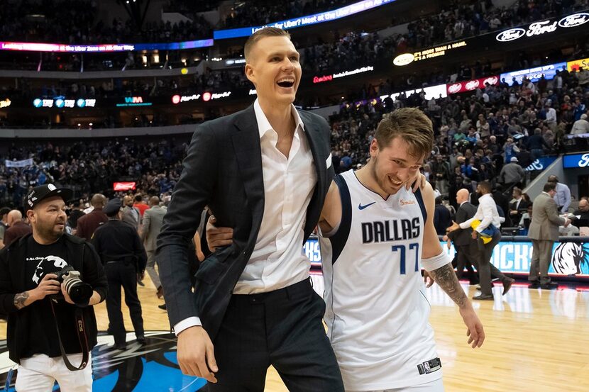 Mavericks guard Luka Doncic (77) hugs forward Kristaps Porzingis as they walk off the floor...