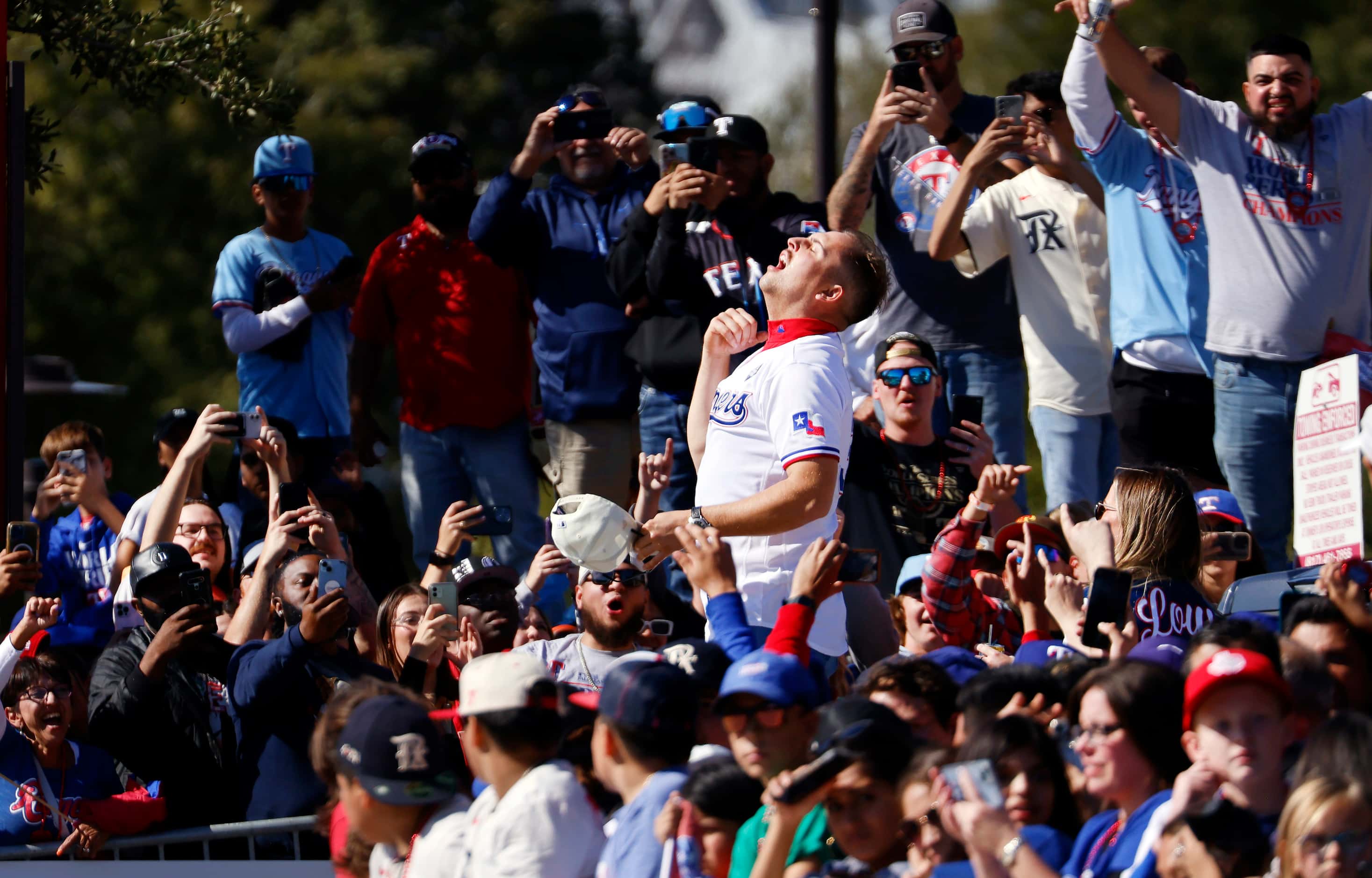 Texas Rangers first baseman Nathaniel Lowe yes after chugging a beer for fans during the...