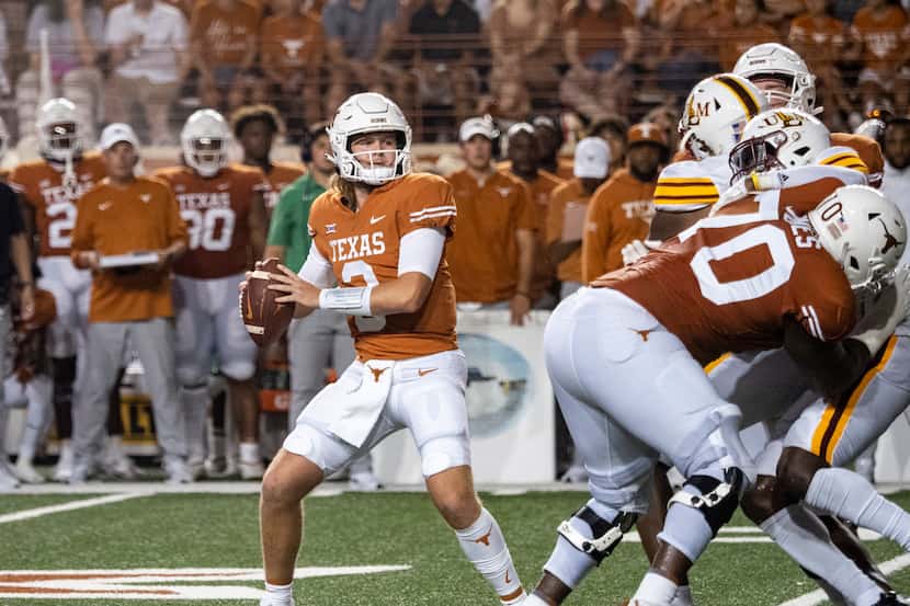 Texas quarterback Quinn Ewers, front left, looks to pass during the first half of an NCAA...