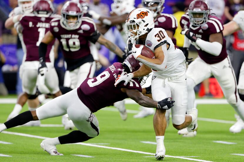 Oklahoma State running back Chuba Hubbard (30) is caught by Texas A&M defensive back Leon...