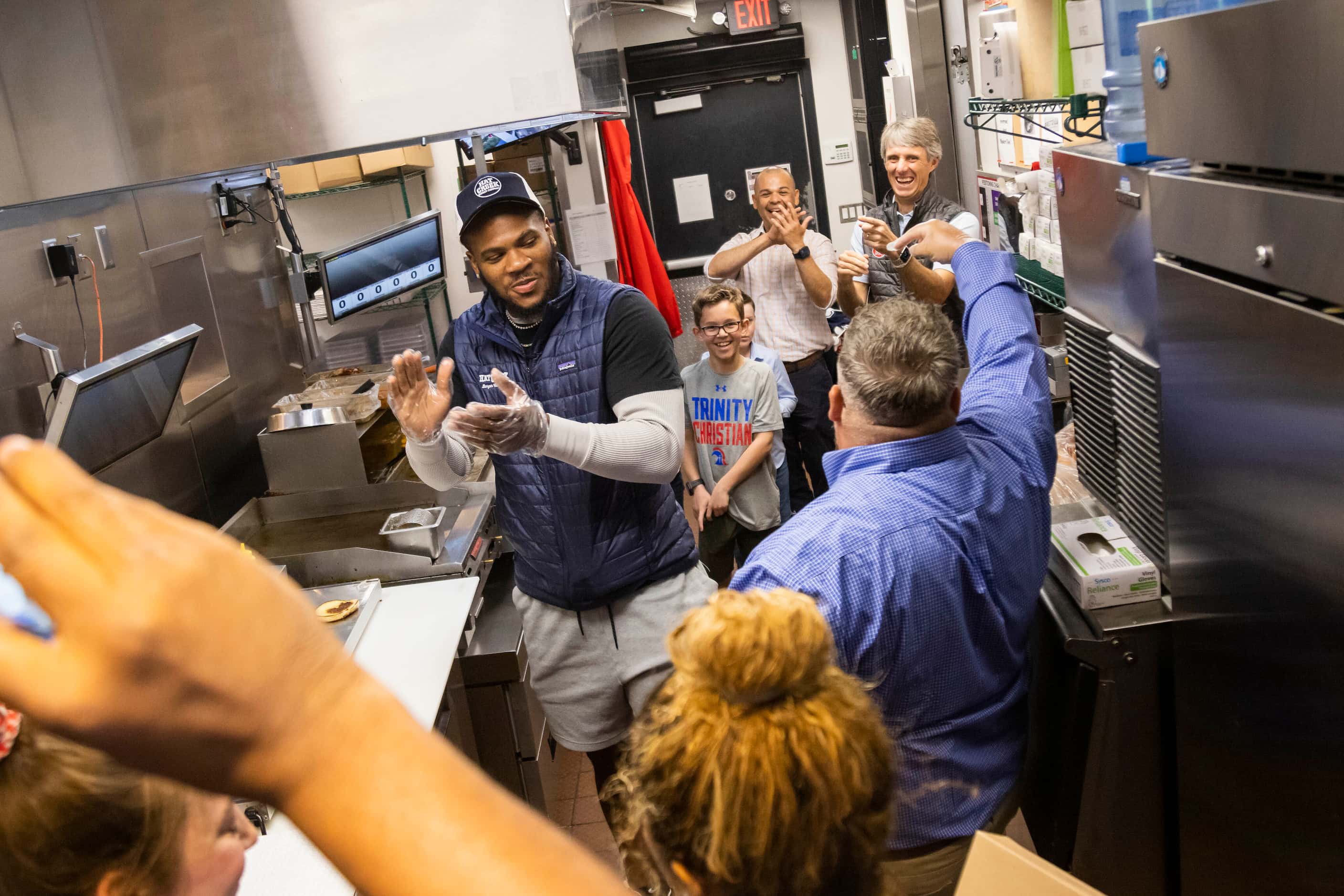 Dallas Cowboys linebacker Micah Parsons claps while trying the Giveback Burger he made at...