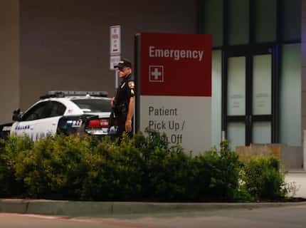 A Dallas police officer stands guard at the emergency room entrance to Parkland Hospital...