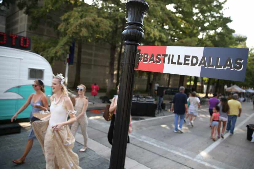Attendees walk along Harwood Street at Bastille Day in the Arts District in Dallas on...