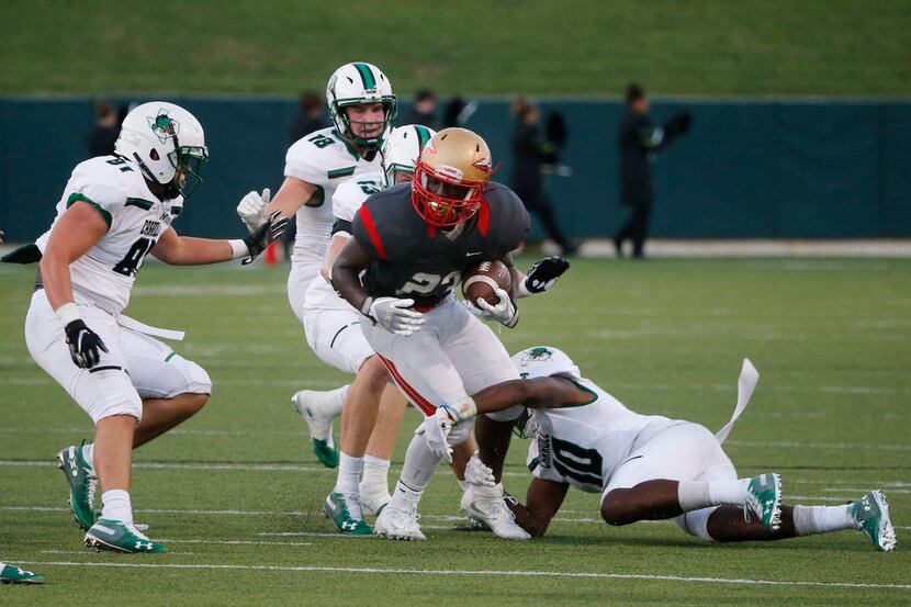 South Grand Prairie tailback Javarius Crawford is tackled by Southlake Carroll defenders...