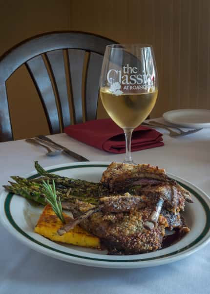 A glass of white wine paired with rack of lamb with a mint herb crust and rosemary...