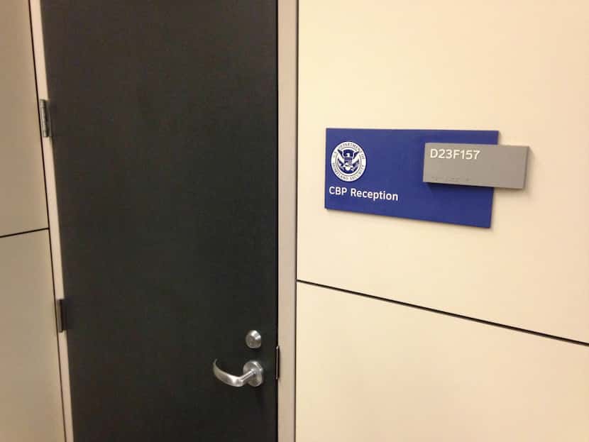 The locked U.S. Customs and Border Protection door at DFW International Airport behind which...