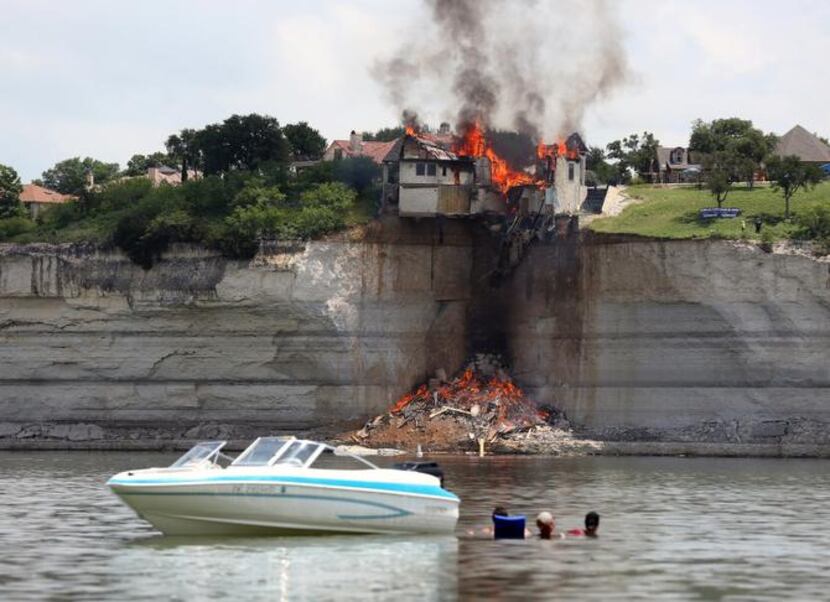 
Boaters watched as the home  overlooking Lake Whitney was engulfed by fire Friday.