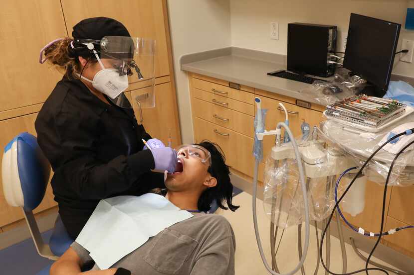 Mari Rodriguez (left), a first-year student, performs a cleaning on Zach Zavala at the...