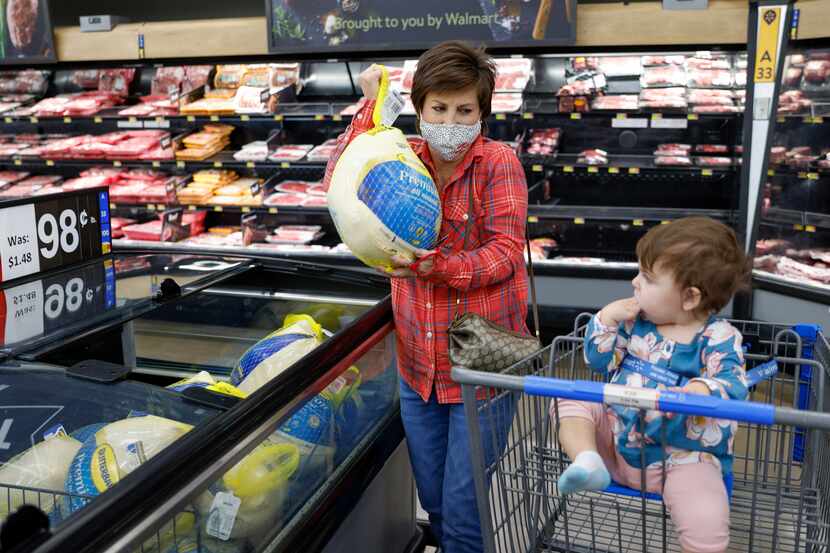 Melissa Hood, 58, picks up a Butterball frozen turkey as her granddaughter Emerson Hood, 3,...