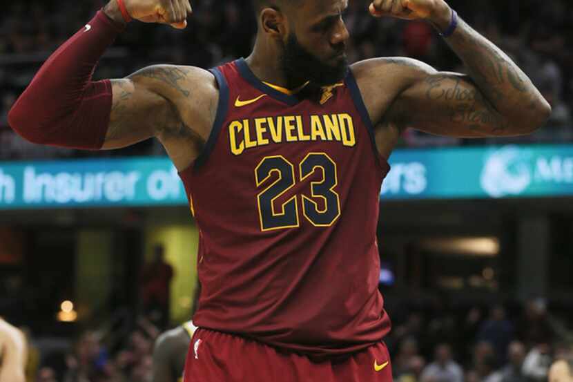 The Clevland Cavaliers' LeBron James flexes after making a basket and drawing a foul against...