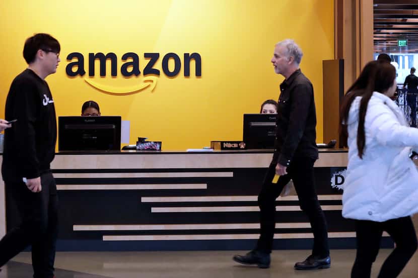 Employees walk through a lobby at Amazon's headquarters Nov. 13, 2018, in Seattle. Amazon,...