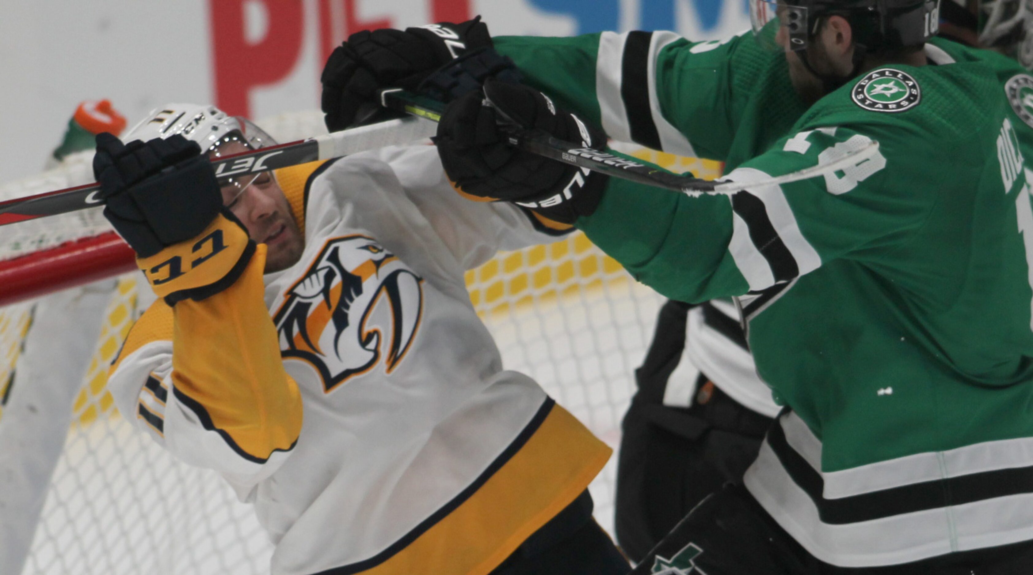 Dallas Stars' Jason Dickinson (18), right, tangles with Nashville Predators' Luke Kunin (11)...