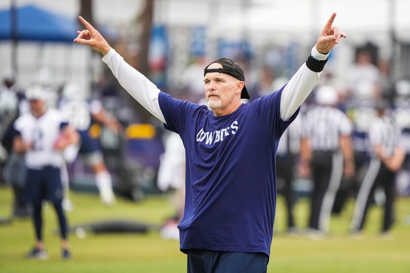 Dallas Cowboys defensive coordinator Dan Quinn motions to players during a practice at...