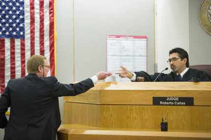 Defense attorney Bob Hinton passes a paper to Judge Roberto Cañas as former Texas A&M and...