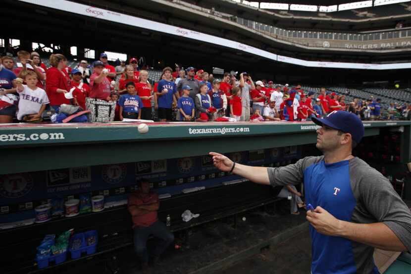 Texas Rangers first baseman Mitch Moreland (18) tosses a signed ball to a Rangers fan during...