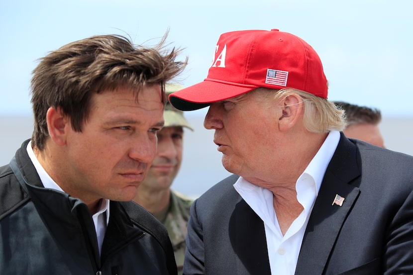 FILE - President Donald Trump talks to Florida Gov. Ron DeSantis, left, during a visit to...