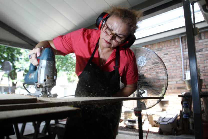 "The Sign Lady" Cindy Villela, cuts portions of a light-weight wood which will be used for...