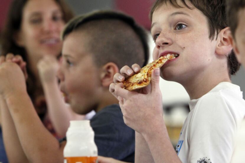Nine-year-old Brendan Durrett chows down on pizza at the Mesquite Summer Nutrition program...