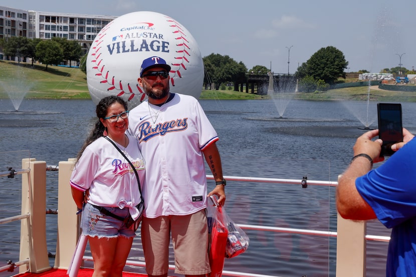 Rosa and Anthony Flores pose for a photo in front of a large baseball at the MLB All-Star...