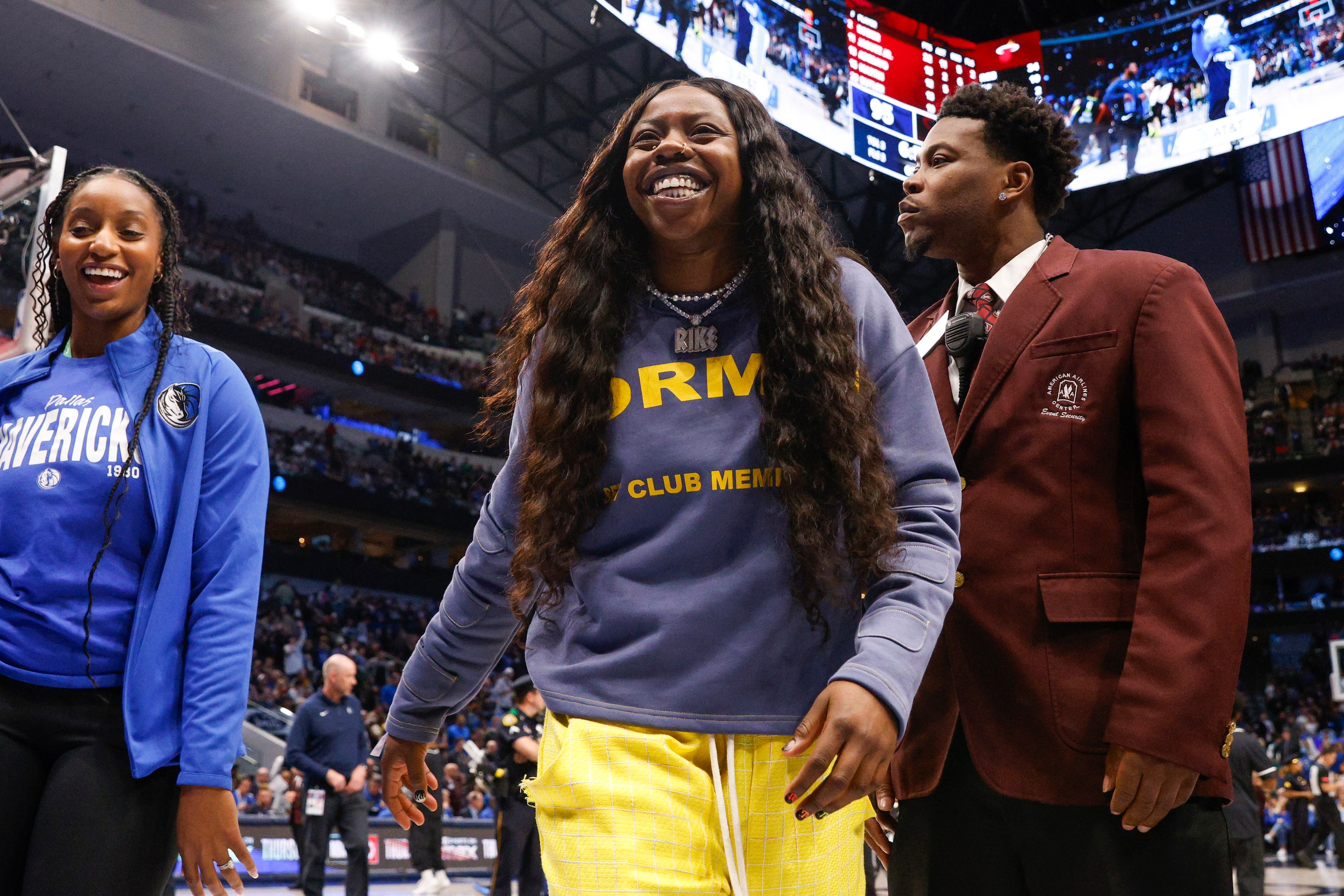 Dallas Wings guard Arike Ogunbowale smiles after throwing shirts to fans during the second...