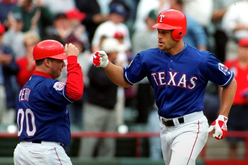 Former Texas Rangers outfielder Gabe Kapler is congratulated at home plate by the Rangers...