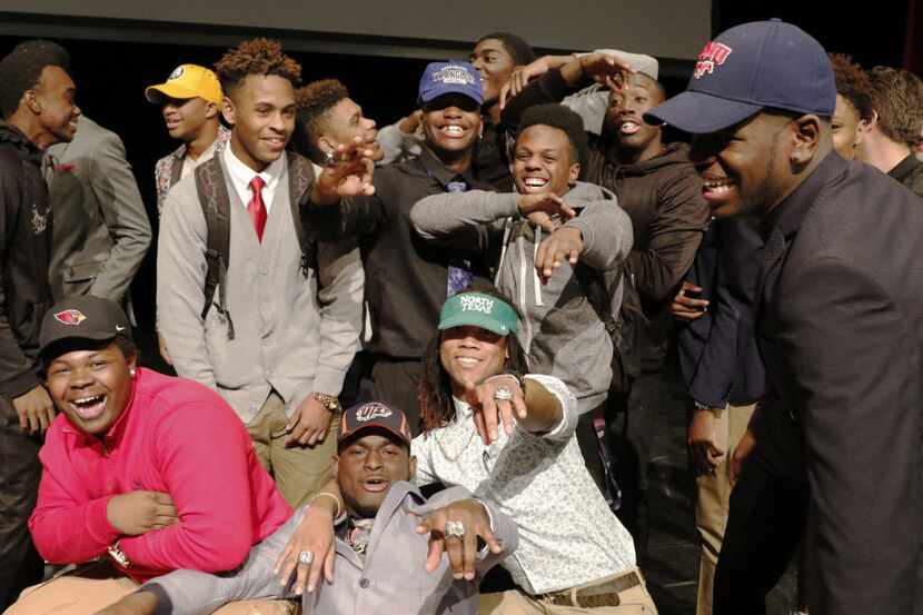 Cedar Hill High School football players pose for photos after signing letters of intent to...