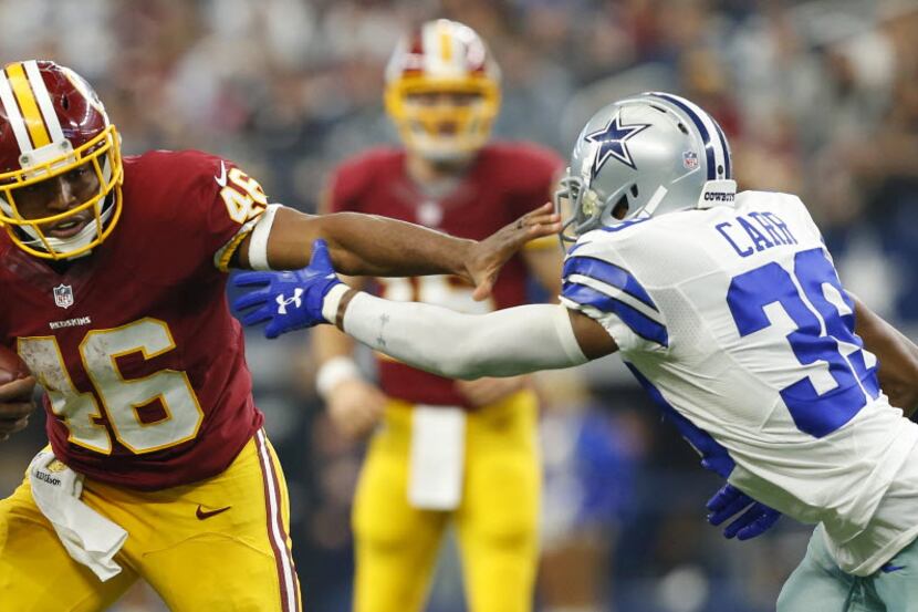 Washington Redskins running back Alfred Morris (46) gives a stiff arm to Dallas Cowboys...