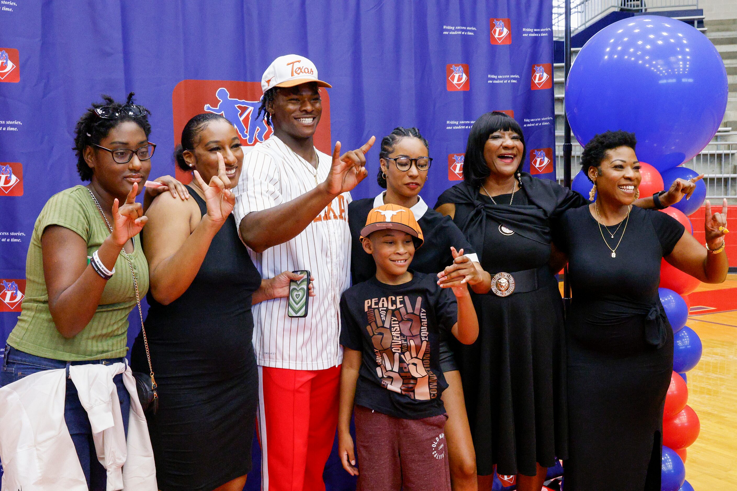 Duncanville defensive lineman Colin Simmons holds up “Hook ‘em Horns” as he poses for a...