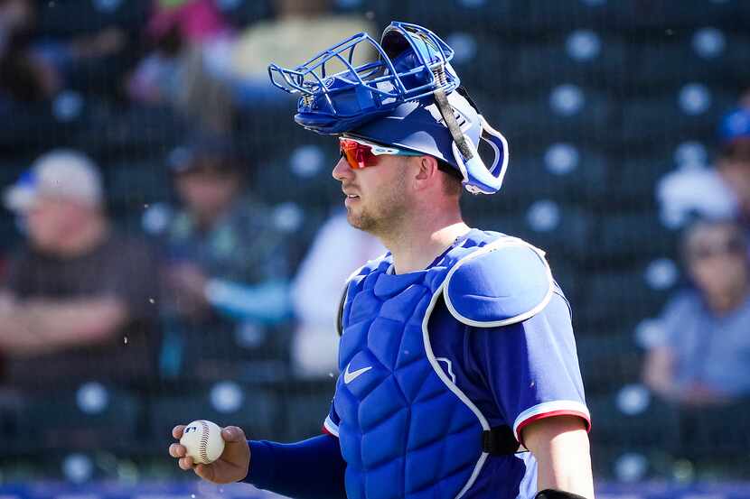 Texas Rangers catcher Mitch Garver gets a new ball during the fifth inning of a spring...