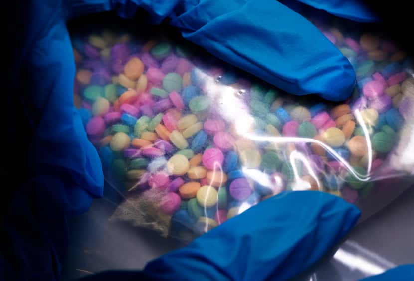 Hundreds of seized rainbow-colored fentanyl pills are held at the Drug Enforcement...