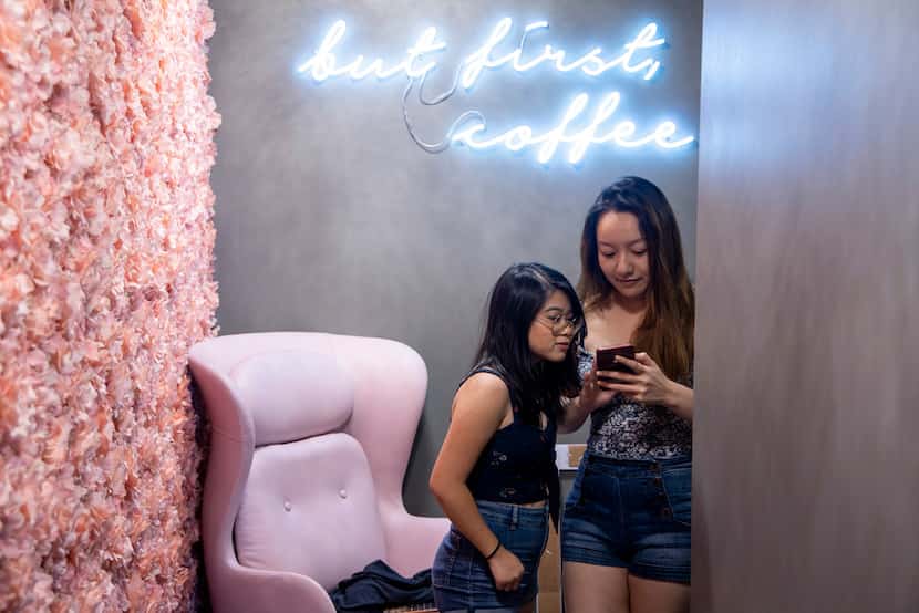 Michellle Le, 16, left, looks at picture on Tiffany Nguyen's phone at Pink Coffee in...
