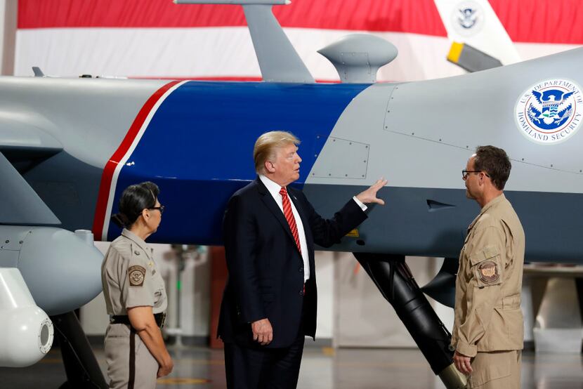 President Donald Trump touches an unmanned aerial vehicle during a tour of U.S. Customs and...