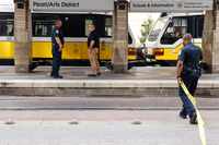A DART police officer removes yellow tape at the DART Pearl/Arts District Station as the...