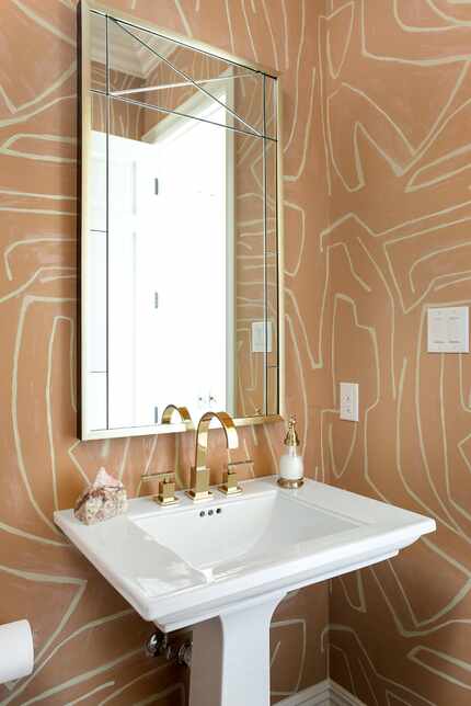 A powder bathroom is covered in a graphic wallpaper.